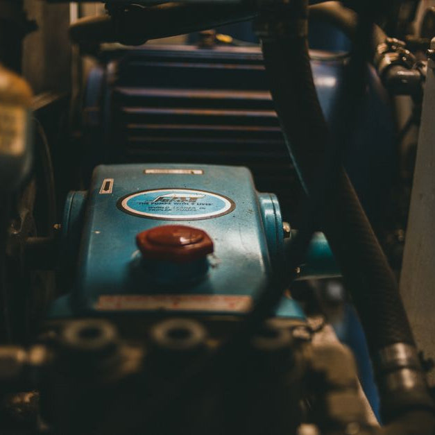 Detailed view of a blue industrial engine with mechanical parts and hoses.