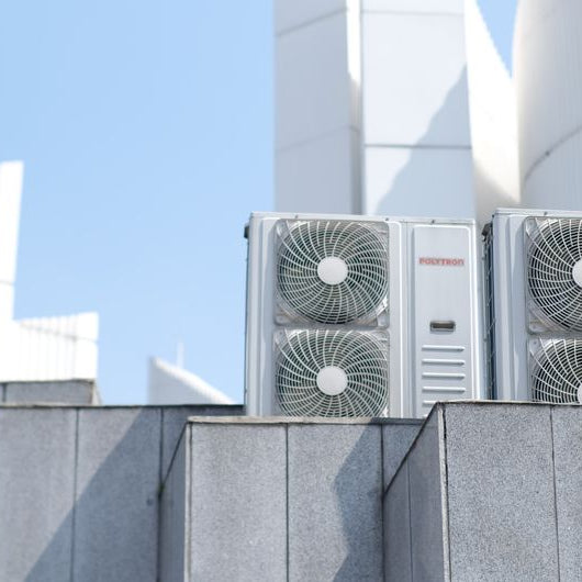 Air conditioner units on a city rooftop in Bandung, Indonesia, showcasing modern urban architecture.